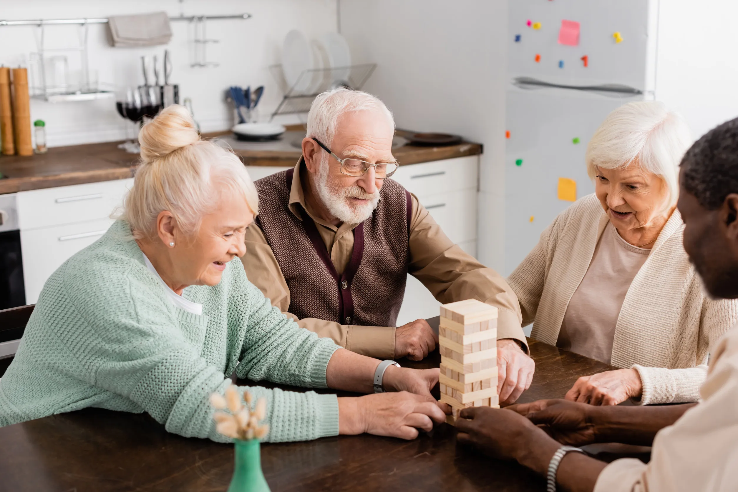 cheerful interracial pensioners smiling while playing tower wood blocks game at home cheerful interracial pensioners smiling while playing tower wood blocks game at home